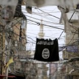 An Islamic State flag hangs amid electric wires over a street in Ain al-Hilweh Palestinian refugee camp, near the port-city of Sidon, southern Lebanon January 19, 2016. REUTERS/Ali Hashisho