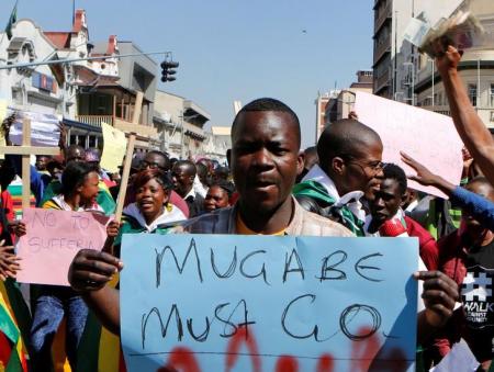 Zimbabweans hold placards during a protest against President Robert Mugabe government's handling of the economy in Harare, Zimbabwe, August 3, 2016. REUTERS/Philimon Bulawayo