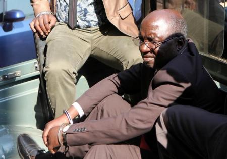 Douglas Mahiya, information secretary of the Zimbabwe National Liberation War Veterans Association (ZNLWVA) is escorted by detectives as he arrives at the Harare Magistrates' court, July 29, 2016.   REUTERS/Philimon Bulawayo