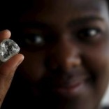 A visitor holds a diamond during a visit to the De Beers Global Sightholder Sales (GSS) in the capital Gaborone in Botswana, November 24, 2015. REUTERS/Siphiwe Sibeko