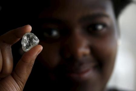 A visitor holds a diamond during a visit to the De Beers Global Sightholder Sales (GSS) in the capital Gaborone in Botswana, November 24, 2015. REUTERS/Siphiwe Sibeko