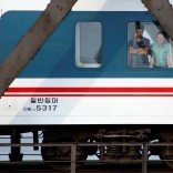 Men look out of a the window of a train that travels across Friendship Bridge from North Korea to China's Dandong, Liaoning province, September 12, 2016.  REUTERS/Thomas Peter
