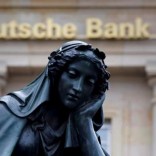 A statue is seen next to the logo of Germany's Deutsche Bank in Frankfurt, Germany, January 26, 2016.    REUTERS/Kai Pfaffenbach/File Photo