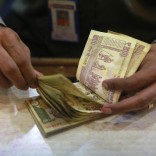A cashier counts Indian rupee currency notes inside a bank in Mumbai August 5, 2013. REUTERS/Danish Siddiqui