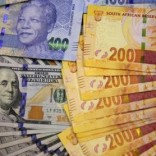 South African bank notes featuring images of former South African President Nelson Mandela (R) are displayed next to the American dollar notes in this photo illustration in Johannesburg August 13 2014.    REUTERS/Siphiwe Sibeko