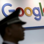 A security guard keeps watch as he walks past a logo of Google in Shanghai, China, April 21, 2016. REUTERS/Aly Song/File Photo