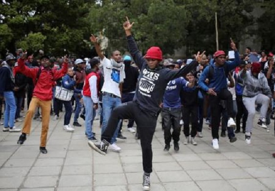 Students chant slogans during clashes with the South African police protect at Johannesburg's University of the Witwatersrand, South Africa, October 4, 2016. REUTERS/Siphiwe Sibeko