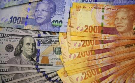 South African bank notes featuring images of former South African President Nelson Mandela (R) are displayed next to the American dollar notes in this photo illustration in Johannesburg August 13 2014.    REUTERS/Siphiwe Sibeko