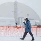 A worker is seen in front of a New Safe Confinement (NSC) structure over the old sarcophagus covering the damaged fourth reactor at the Chernobyl nuclear power plant, Ukraine, November 29, 2016.  REUTERS/Gleb Garanich