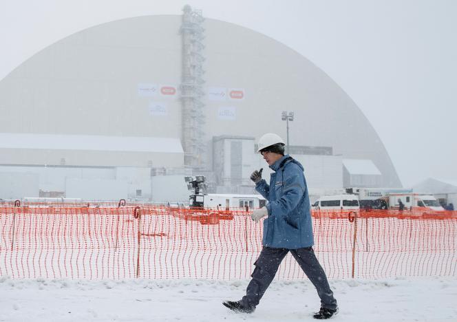 A worker is seen in front of a New Safe Confinement (NSC) structure over the old sarcophagus covering the damaged fourth reactor at the Chernobyl nuclear power plant, Ukraine, November 29, 2016.  REUTERS/Gleb Garanich