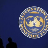 Visitors are silhouetted against the logo of the International Monetary Fund at the main venue for the IMF and World Bank annual meeting in Tokyo October 10, 2012.   REUTERS/Kim Kyung-Hoon