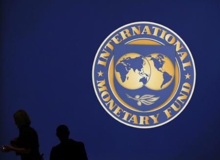 Visitors are silhouetted against the logo of the International Monetary Fund at the main venue for the IMF and World Bank annual meeting in Tokyo October 10, 2012.   REUTERS/Kim Kyung-Hoon