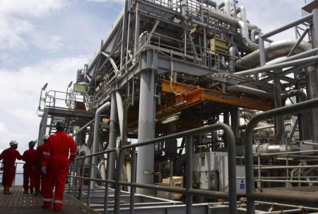 Oil workers walk through pipe installations on a tanker at Bonga off-shore oil field outside Lagos,  file. NIGERIA-BONGA/.