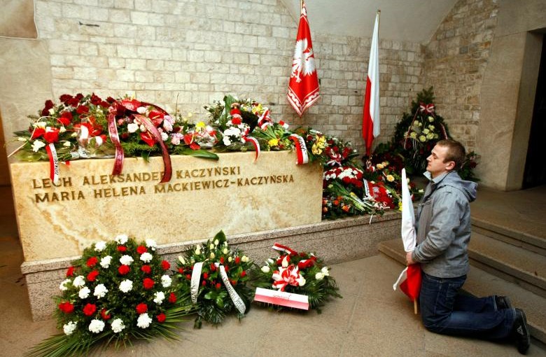 A man prays in front of the sarcophagus of the late President Lech Kaczynski during an event commemorating the first year anniversary of his funeral in Krakow April 18, 2011.   REUTERS/Kacper Pempel