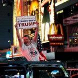 A man leans out of a Hummer shouting words in support of Donald Trump while driving through Times Square in New York. REUTERS/Mark Kauzlarich