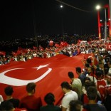 Pro-government demonstrators hold a giant Turkish flag during a march over the Bosphorus Bridge from the Asian to the European side of Istanbul, Turkey, July 21, 2016.  REUTERS/Osman Orsal