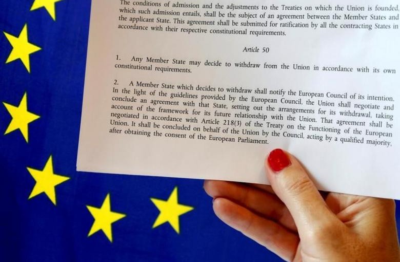 Article 50 of the EU's Lisbon Treaty that deals with the mechanism for departure is pictured near an EU flag following Britain's referendum results to leave the European Union, in this photo illustration taken in Brussels, Belgium, June 24, 2016. REUTERS/Francois Lenoir/Illustration/File Photo