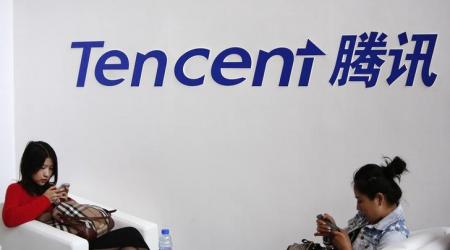 Visitors use their smarts phones underneath the logo of Tencent at the Global Mobile Internet Conference in Beijing May 6, 2014.  Chinese internet service provider Tencent Holdings plans to acquire an 11.3 percent stake in digital mapping service provider Navinfo Co Ltd for 1.17 billion yuan ($187.33 million), Navinfo said late on Monday.   REUTERS/Kim Kyung-Hoon