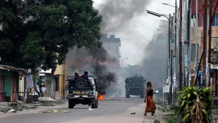 Congolese policemen drive past a fire barricade during demonstrations in the streets of the Democratic Republic of Congo's capital Kinshasa, December 20, 2016. REUTERS/Thomas Mukoya