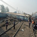 Rescuers and railway officials stand next to damaged coaches of a passenger train after it derailed near Kanpur in the northern state of Uttar Pradesh, India, December 28, 2016. REUTERS/Stringer