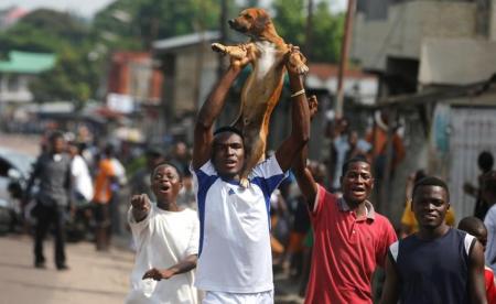 Congolese opposition party supporters carry a dog as they chant slogans in a street of Democratic Republic of Congo's capital Kinshasa, December 19, 2016. REUTERS/Thomas Mukoya