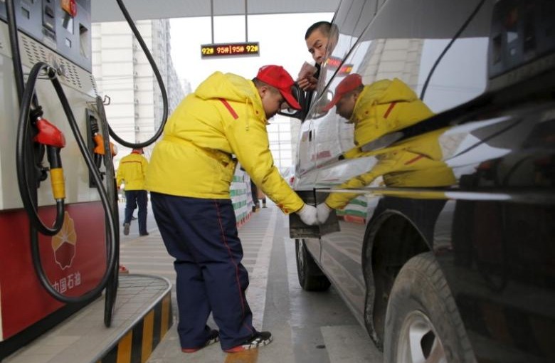 A gas station attendant pumps fuel into a customer's car at PetroChina's petrol station in Beijing, China, March 21, 2016.  REUTERS/Kim Kyung-Hoon