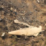 Rescue workers survey the site of a plane crash in the vilage of Saddha Batolni near Abbotabad, Pakistan December 8, 2016. . REUTERS/Faisal Mahmood