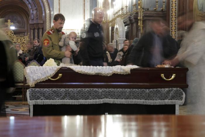 People walk past the coffin containing the body of Russian ambassador to Turkey Andrei Karlov, who was shot dead by an off-duty policeman while delivering a speech in an Ankara art gallery on December 19, during a memorial service at the Christ the Savior Cathedral in Moscow, Russia December 22, 2016. REUTERS/Maxim Shemetov