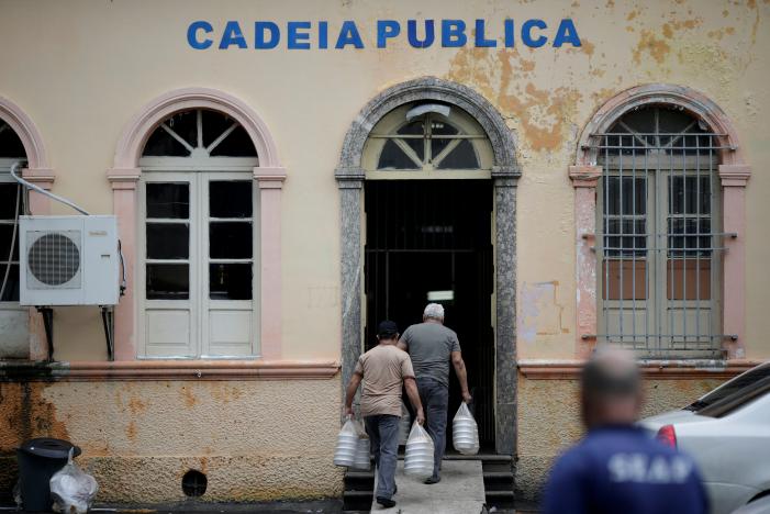 Men are seen in front of the public jail in Manaus, Brazil, after some prisoners were relocated following a deadly prison riot, January 4, 2017. REUTERS/Ueslei Marcelino