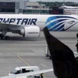 A passenger reads a newspaper at a departure hall of London's Heathrow terminal as an EgyptAir plane taxis on the tarmac of the airport May 20, 2016.  REUTERS/Yannis Behrakis