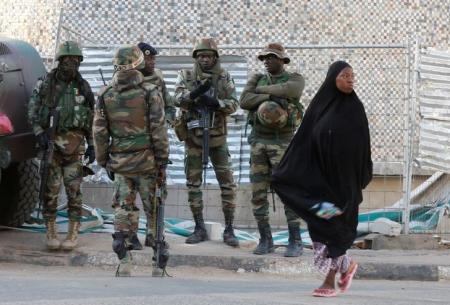 A woman passes near members of the regional ECOWAS, in Banjul, Gambia January 23, 2017. REUTERS/Thierry Gouegnon