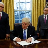 U.S. President Donald Trump signs an executive order on U.S. withdrawal from the Trans Pacific Partnership while flanked by Vice President Mike Pence (L) and White House Chief of Staff Reince Priebus (R) in the Oval Office of the White House in Washington January 23, 2017.   REUTERS/Kevin Lamarque