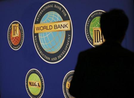 A man is silhouetted against the logo of the World Bank at the main venue for the International Monetary Fund (IMF) and World Bank annual meeting in Tokyo October 10, 2012.   REUTERS/Kim Kyung-Hoon
