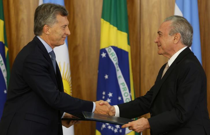 Argentine President Mauricio Macri (L) and his Brazilian counterpart Michel Temer exchange documents after a meeting at the Planalto Palace in Brasilia, Brazil February 7, 2017. REUTERS/Adriano Machado