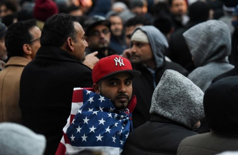 Mohammed Abdul wraps himself in an American flag before a prayer session during a protest by the Yemeni community against U.S. President Donald Trump's travel ban in the Brooklyn borough of New York City, U.S. February 2, 2017. REUTERS/Stephanie Keith