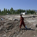 A boy walks past the demolished site of a compound of Osama bin Laden in Abbottabad May 2, 2012. Osama bin Laden was killed a year ago, on May 2, 2011, by a United States special operations military unit in a raid on his compound in Abbottabad.  REUTERS/Mian Khursheed