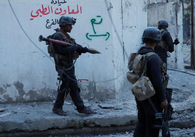 Iraqi Special Forces soldiers walk on a street before they search a house for Islamic State fighters in Mosul, Iraq February 27, 2017. REUTERS/Goran Tomasevic