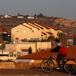 A boy rides his bicycle past houses in the Israeli settlements of Ofra, in the occupied West Bank February 6, 2017. REUTERS/Baz Ratner