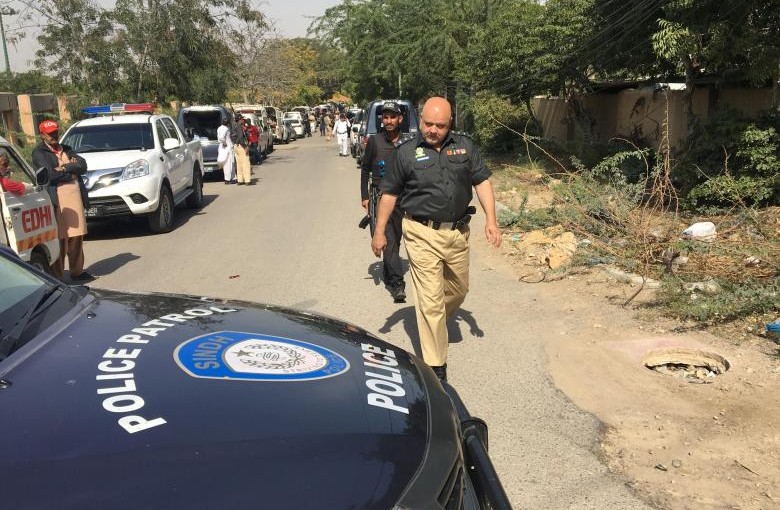 A policeman walks past a police vehicle parked to cordon a street leading to the Afghan consulate in Karachi, after an Afghan diplomat was shot dead on Monday in the consulate, Pakistan February 6, 2017. REUTERS/Akhtar Soomro