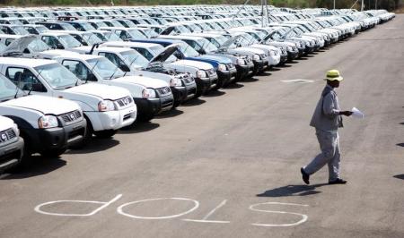 A worker walks near a row of cars at Nissan's manufacturing plant in Rosslyn, outside Pretoria,  file.   REUTERS/Siphiwe Sibeko/File Photo