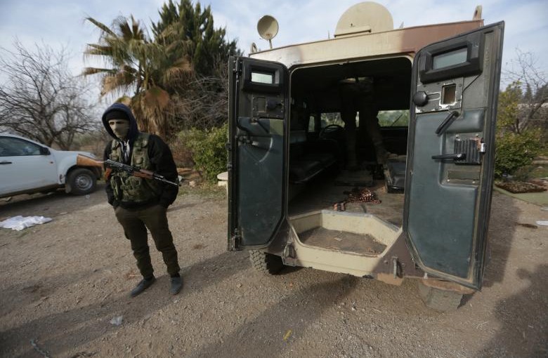 A rebel fighter stands with his weapon near a military vehicle on the outskirts of the northern Syrian town of al-Bab, Syria February 8, 2017. REUTERS/Khalil Ashawi