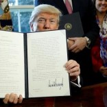 After signing, U.S. President Donald Trump holds up an executive order rolling back regulations from the 2010 Dodd-Frank law on Wall Street reform at the White House in Washington February 3, 2017.  REUTERS/Kevin Lamarque