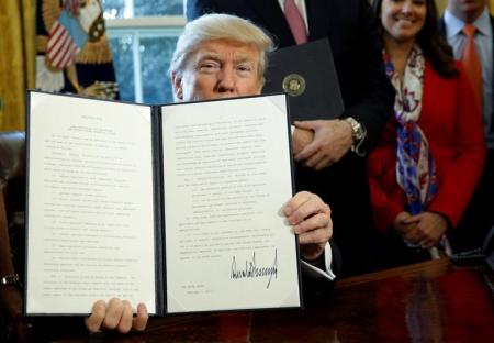 After signing, U.S. President Donald Trump holds up an executive order rolling back regulations from the 2010 Dodd-Frank law on Wall Street reform at the White House in Washington February 3, 2017.  REUTERS/Kevin Lamarque