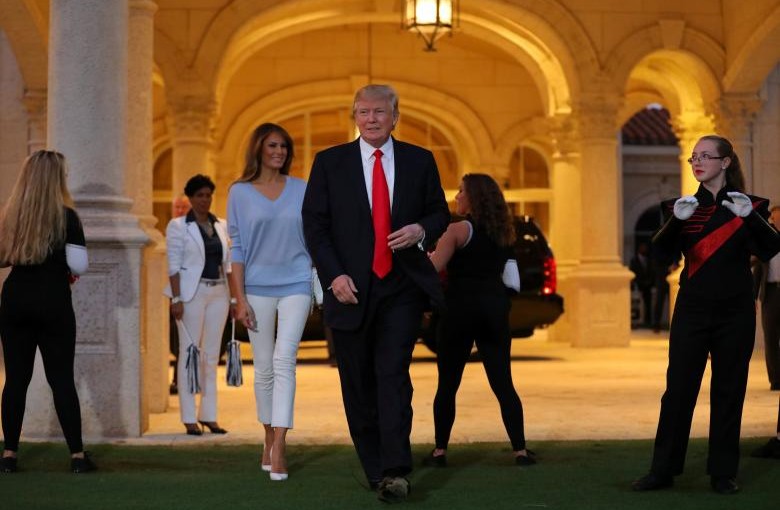 U.S. President Donald Trump and First Lady Melania Trump greet a marching band as they arrive at Trump International Golf club to watch the Super Bowl LI between New England Patriots and Atlanta Falcons in West Palm Beach, Florida, U.S.,  February 5, 2017. REUTERS/Carlos Barria