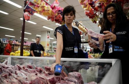 A member of the Public Health Surveillance Agency measures the temperature where the meats are exposed before collecting them to analyse in their laboratory, at a supermarket in Rio de Janeiro, Brazil, March 20, 2017. REUTERS/Ricardo Moraes