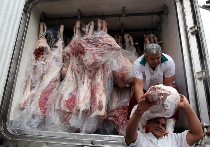 Workers unload packed meat from a truck in Sao Paulo, June 3, 2015. REUTERS/Paulo Whitaker