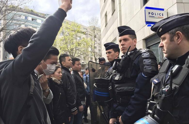 French police face off with members of the Chinese community during a protest demonstration outside a police station in Paris, France, March 28, 2017, after a Chinese man was shot dead by police at his Paris home on Sunday, triggering riots in the French capital by members of the Chinese community and a diplomatic protest by Beijing.    REUTERS/Noemie Olive