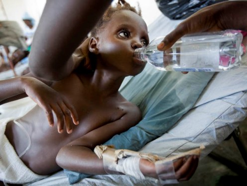 On 17 November, a health worker feeds bottled water to a child being treated for cholera, in a health centre in the impoverished Wharf Jérémie neighbourhood of Port-au-Prince, the capital.

By 17 November 2010 in Haiti, the cholera outbreak that began in Artibonite Department had spread to 7 of the countrys 10 departments, infecting 16,799 people and killing 1,039. In Port-au-Prince, the capital, more than 600 cases and 27 deaths have been reported. Cholera is a deadly bacterial infection spread through contaminated food and water. The health crisis has also provoked civil unrest in the northern town of Cap Haitien, slowing cholera treatment responses there, and is anticipated to spread elsewhere. Port-au-Prince is particularly vulnerable to the disease, with some 1.3 million people  displaced by the 12 January earthquake  living in dense camps. More live in impoverished communities such as Cité Soleil and all lack adequate safe water and sanitation facilities. Even before the quake, Haitis access to sanitation was among the worst in the world. Recovery operations made significant progress in providing safe water and sanitation to quake survivors but communicable diseases have remained a threat. UNICEF is working with the Government and other partners to establish cholera treatment centres throughout the country and disseminate public information on cholera prevention. Haitis sanitation agency, DINEPA (Direction Nationale de l'Eau Potable et de l'Assainissement), is also distributing chlorine tablets and safe water, and testing water sources for contamination. UNICEF has mobilized all critical staff to respond to the crisis and joined other United Nations agencies and partners in a new 12 November appeal for US $163 million  of which UNICEFs portion is US $25.2 million. UNICEF and partners are providing medical teams, distributing water purification supplies, antibiotics, oral rehydration salts (ORS) and therapeutic foods, and accelerating other cholera prevention and treatment efforts throughout the country.
