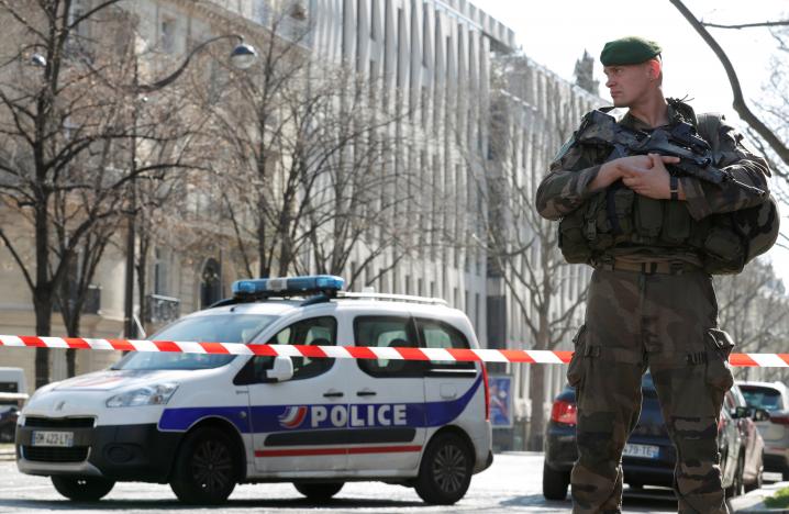 Police and a soldier block the access to the International Monetary Fund (IMF) offices where an envelope exploded in Paris, France, March 16, 2017.  REUTERS/Christian Hartmann
