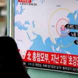 A woman walks past a television broadcasting a news report on North Korea firing ballistic missiles, at a railway station in Seoul, South Korea, March 6, 2017.  REUTERS/Kim Hong-Ji